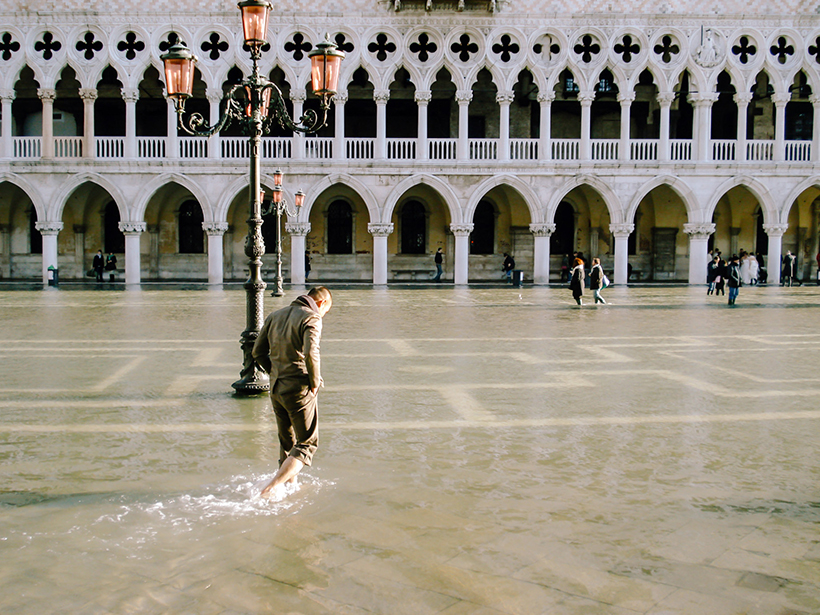 People wade through a foot of water in St. Mark’s Square in Venice, Italy