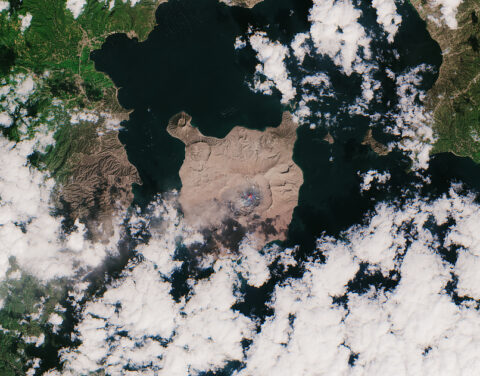 A satellite image of Taal volcano and the surrounding area covered by brown ash A satellite image of Taal volcano and the surrounding area covered by brown ash