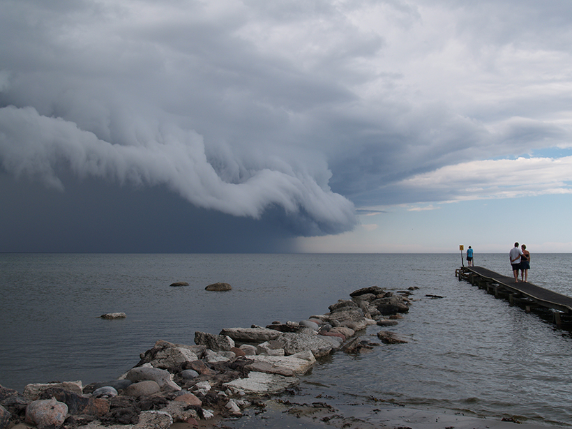 Huge cumulonimbus clouds advance on jetties in the Baltic Sea