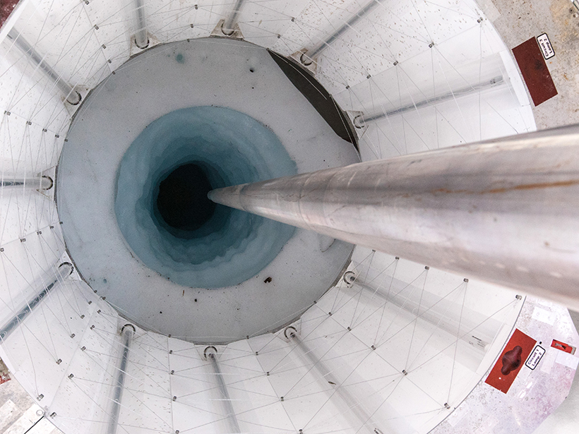 Metal drill going into ice hole