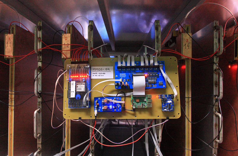 A muographic observation system, looking like a huge motherboard, is attached to a wall.