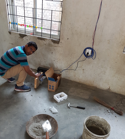 Seismologist Shiba Subedi installs a seismometer in a school in Nepal