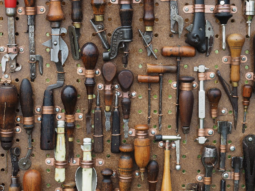 A lot of woodworking tools hang from pegboard
