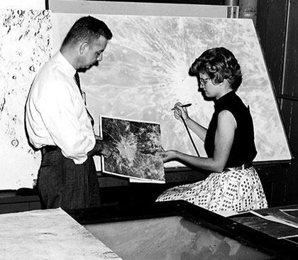 A woman copies a photograph of the Moon’s surface onto a map using an airbrush. A woman copies a photograph of the Moon’s surface onto a map using an airbrush.