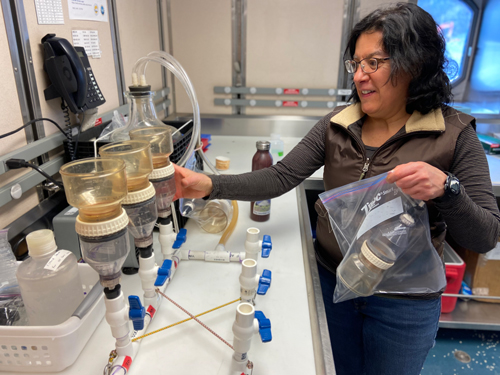 A woman works in a lab on a research ship. A woman works in a lab on a research ship.