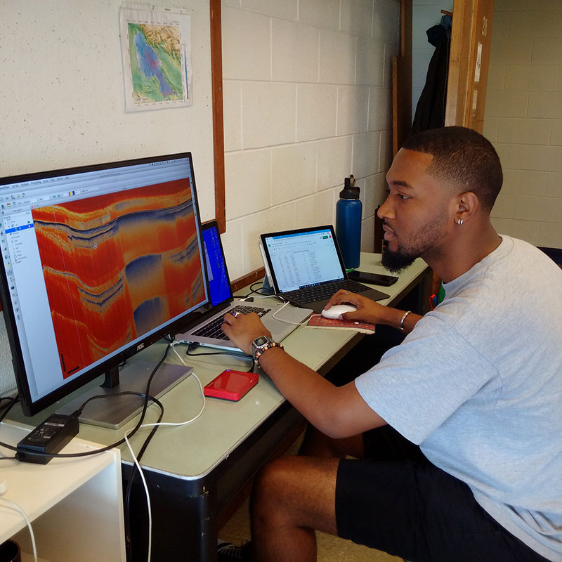 An undergraduate student looks at tectonic profiles on a computer monitor