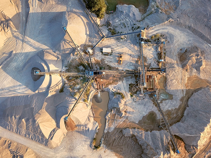 Aerial view of a massive sand-mining machine in the desert