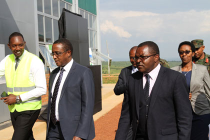 Men in suits tour an industrial e-waste facility