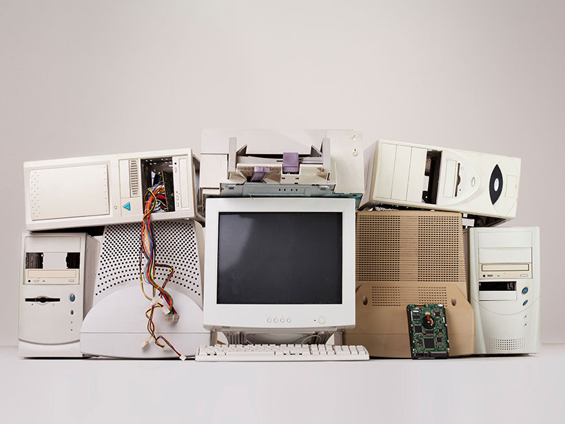 Artfully arranged pile of obsolete computer hardware, including monitor and towers