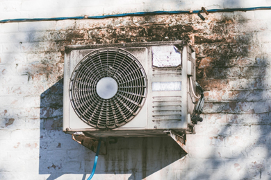 Photograph of an air conditioning unit on the side of a building