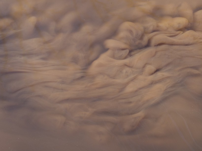 Sediment swirls and mixes with water in a brown slurry