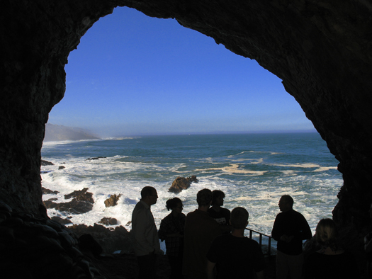 Researchers in a cave entrance are silhouetted against the backdrop of Mossel Bay on the central south coast of South Africa. Researchers in a cave entrance are silhouetted against the backdrop of Mossel Bay on the central south coast of South Africa.
