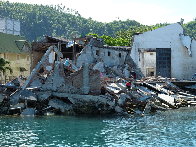 The toppled remains of a building on the shore of Palu Bay in Indonesia following a 2018 earthquake and tsunami