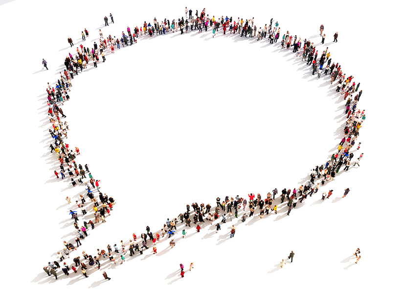 Stock image depicting many people from above standing in the shape of a speech bubble