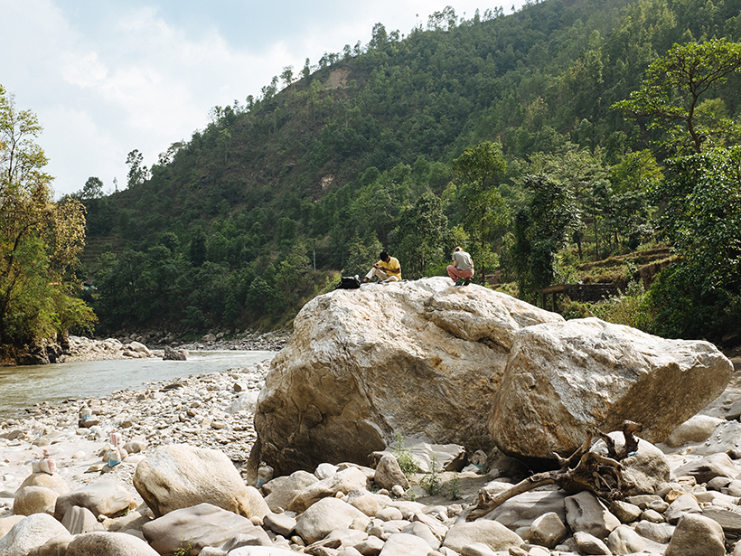 Two people on top of a boulder