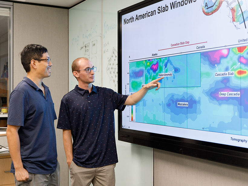 Jonny Wu (left) and Spencer Fuston point to a slide displaying mantle tomography in the North Pacific Ocean.