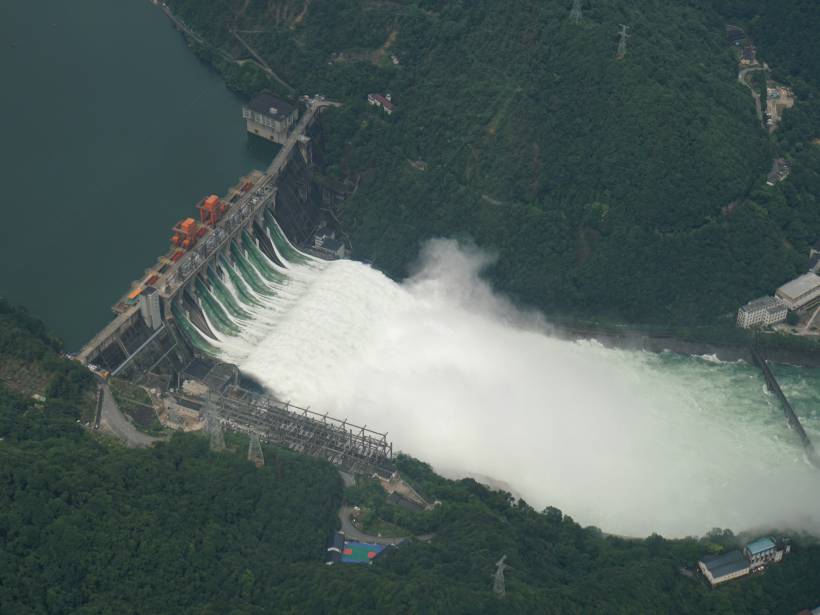 Aerial photograph of the Xin’an River Hydropower Station showing the dam that forms Qiandao Lake releasing flood waters into the river below.