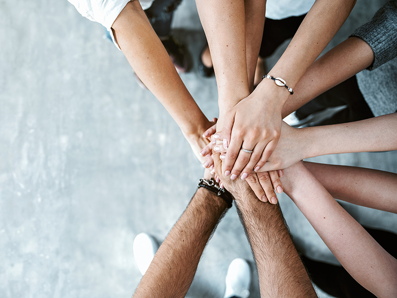 People stacking hands on top of each other