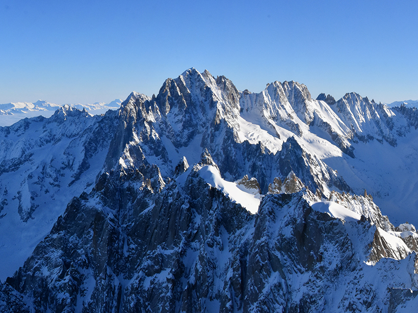 Steep, snow-covered mountains extend to the horizon.