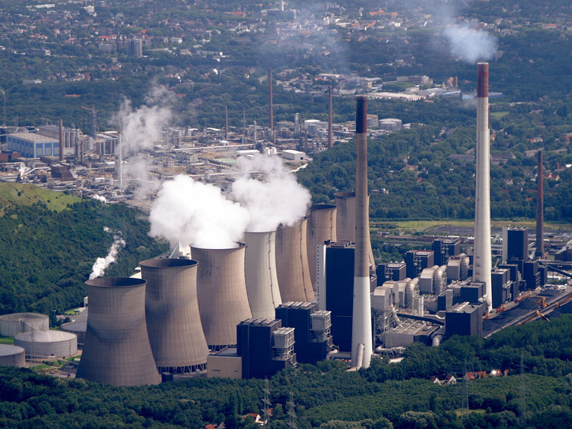 Imagen de una fábrica en un complejo industrial emitiendo gases.
