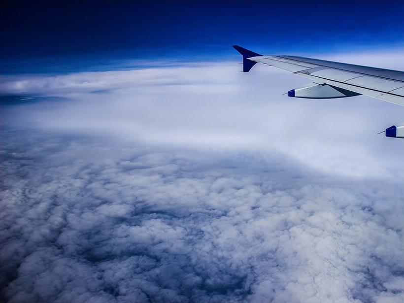 View from an airplane flying above a layer of clouds