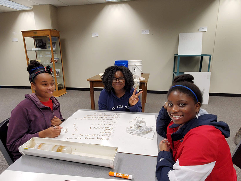 Middle school students sitting around a table at Ohio State University with a homemade ice core