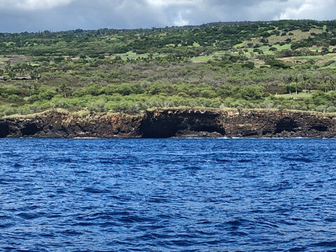 View from the water of lava tubes along the coast of Hawaiʻi near Hualalai volcano