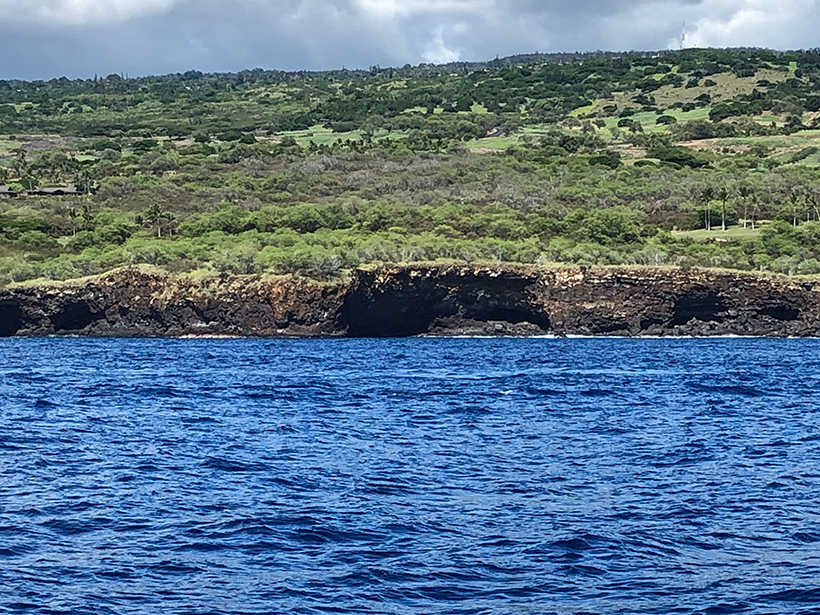 View from the water of lava tubes along the coast of Hawaiʻi near Hualalai volcano