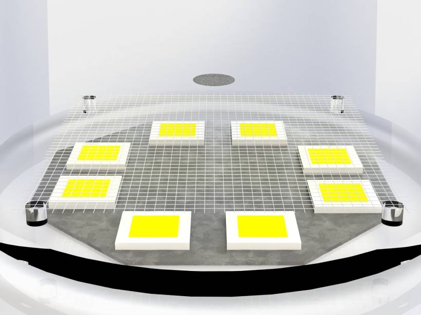 A small plastic disk levitates above an LED array in a vacuum chamber.