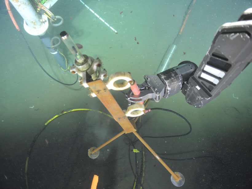 A robotic arm retrieves an underwater hydrophone