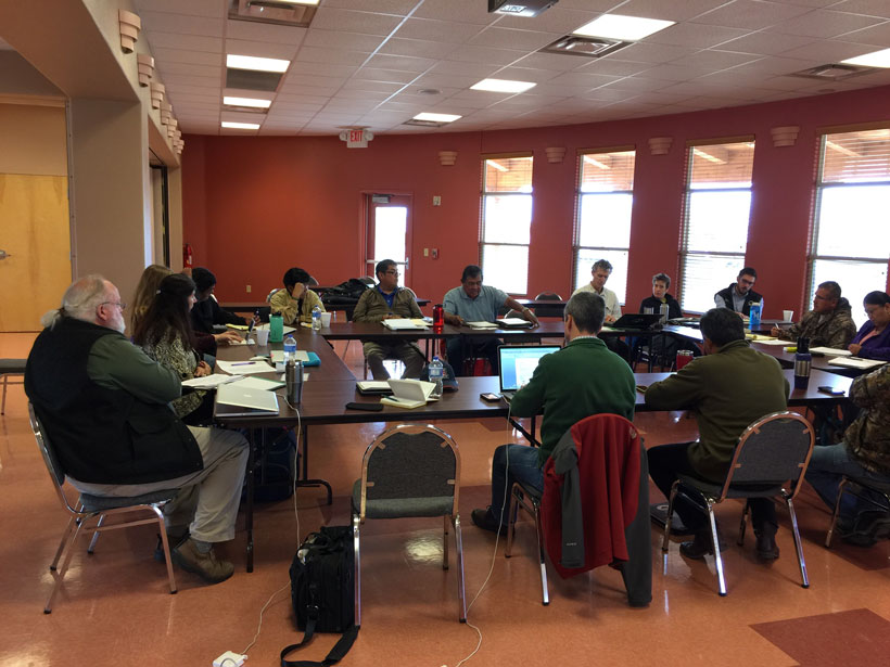 Scientists and tribal members gather round a table to discuss cultural traditions. Scientists and tribal members gather round a table to discuss cultural traditions.