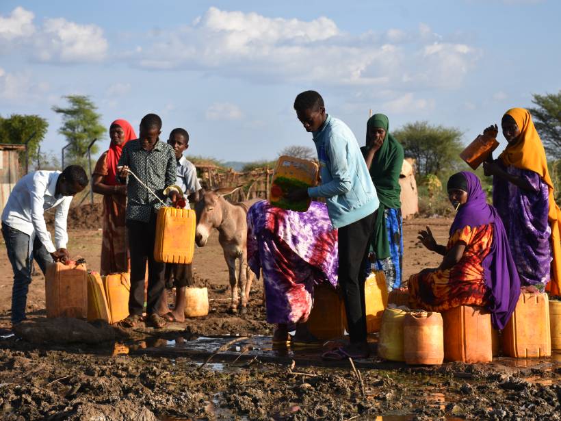 Men and women collect water at a secured borehole in Moyale, Kenya.