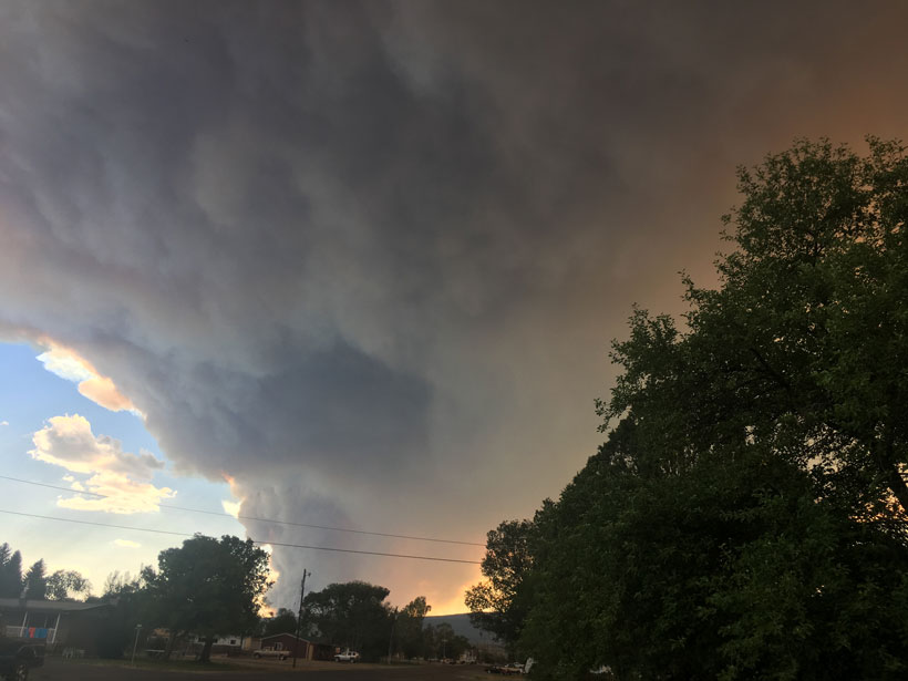 Grandes plumas de humo detrás de casas rurales en Brian Head, Utah, 2017