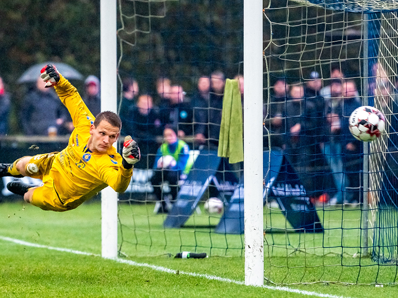 A soccer goalie dives for the ball
