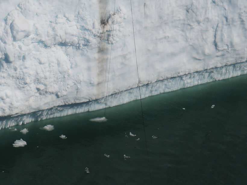 A cable hanging off an ice cliff being pulled by water currents A cable hanging off an ice cliff being pulled by water currents