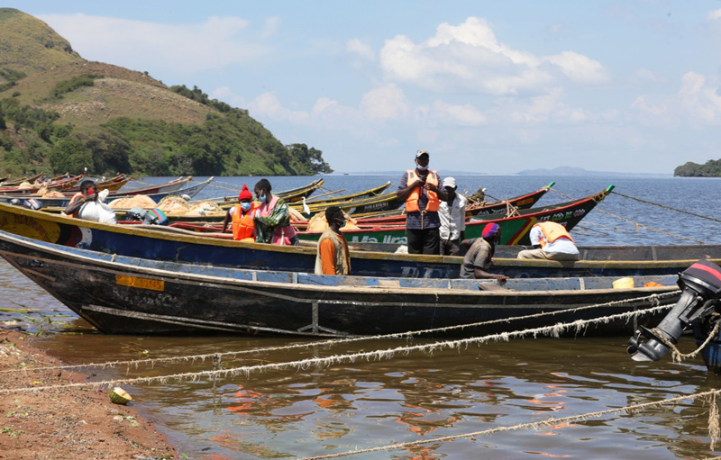 People on docked fishing boats on the shores of Lake Victoria