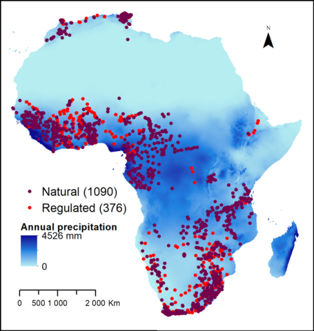 Map of Africa showing the location of each measurement station, where the color of each dot corresponds to whether the water source is natural or regulated by a dam. The color map corresponds to the amount of annual precipitation received by each region.
