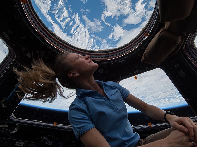 NASA astronaut Karen Nyberg enjoys a view of Earth from the windows of the International Space Station. Earth looks blue and white, with a thin layer of atmosphere at its limb.