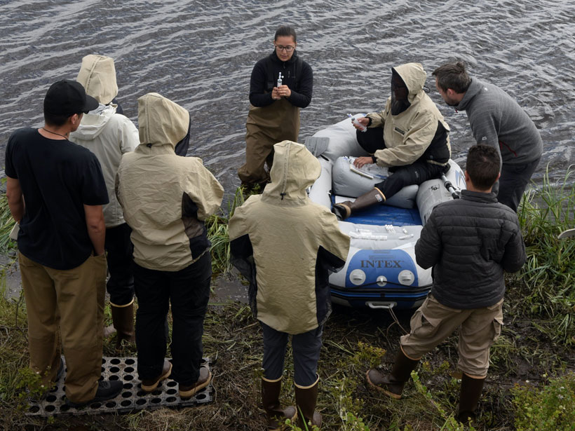 Peter demonstrates water sampling to environmental science students.