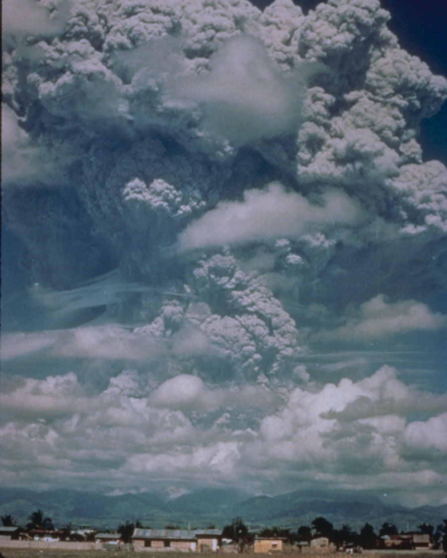 View from ground level of an enormous volcanic plume erupting into the sky