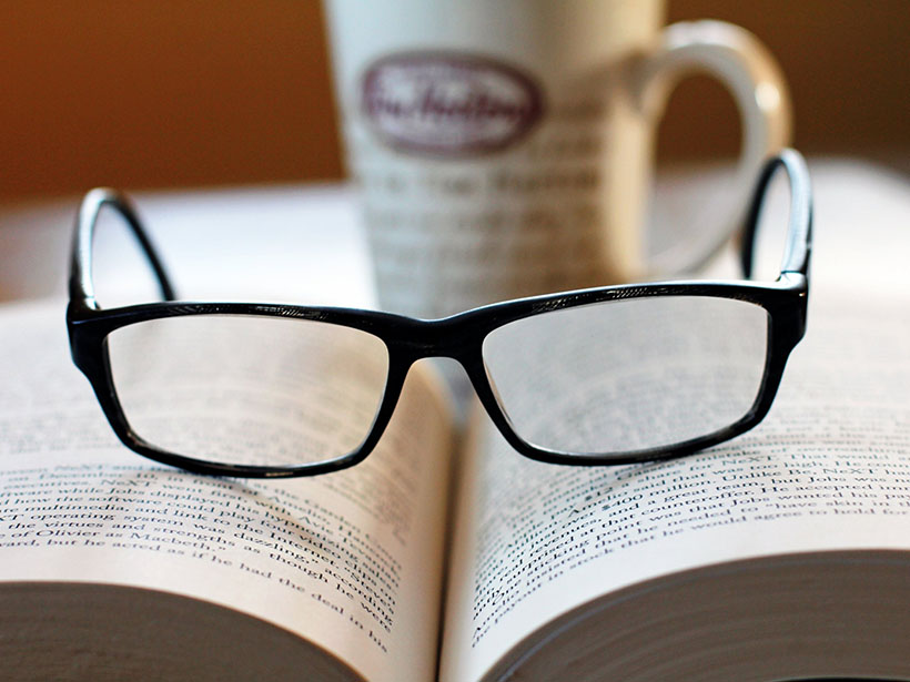 A photo of glasses on top of an open book