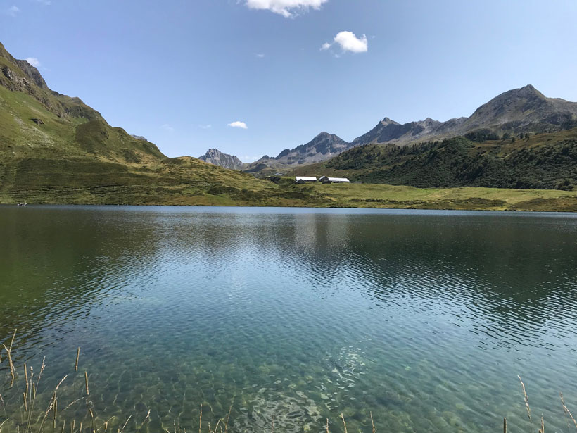 Lake Cadagno—an alpine lake in Switzerland with calm blue-green waters surrounded by sharp-peaked mountains