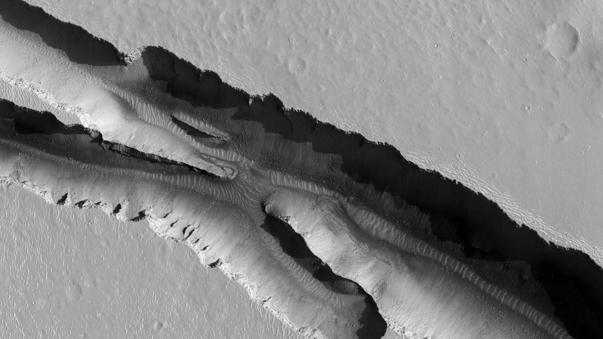 Image of a canyon in the Cerberus Fossae region on Mars. One side of the canyon is in shadow, whereas the other is brightly illuminated.