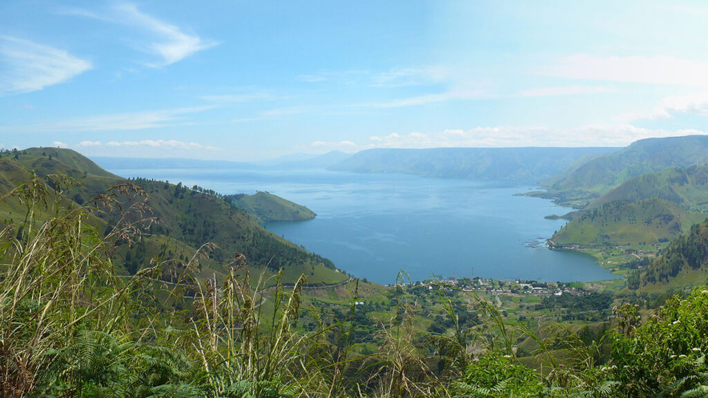 An inlet of Lake Toba in Indonesia, surrounded by tropical vegetation