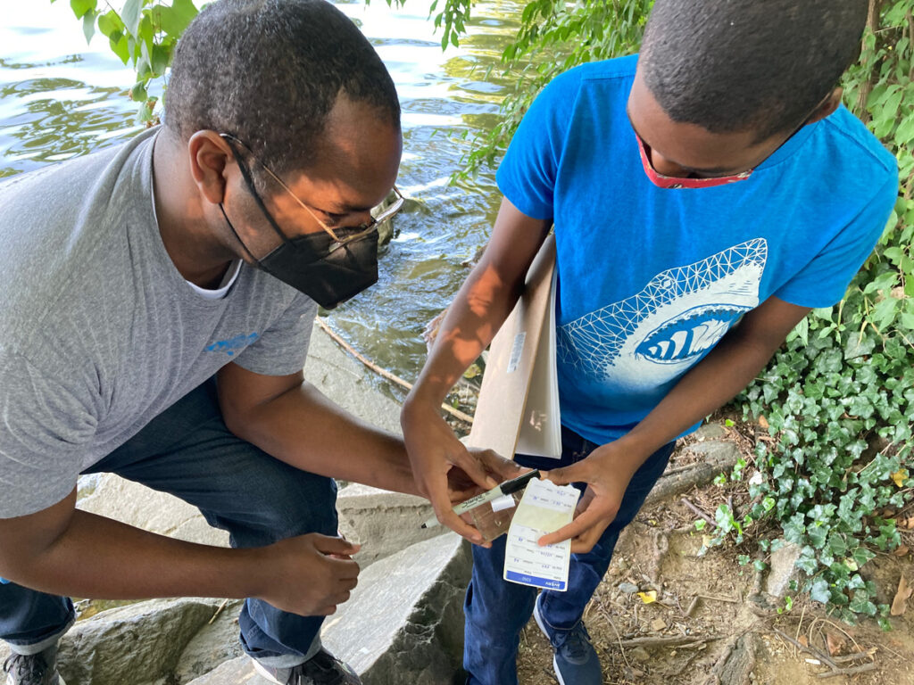 Adrian Bostic and his son, also named Adrian, take water samples from the Potomac River.