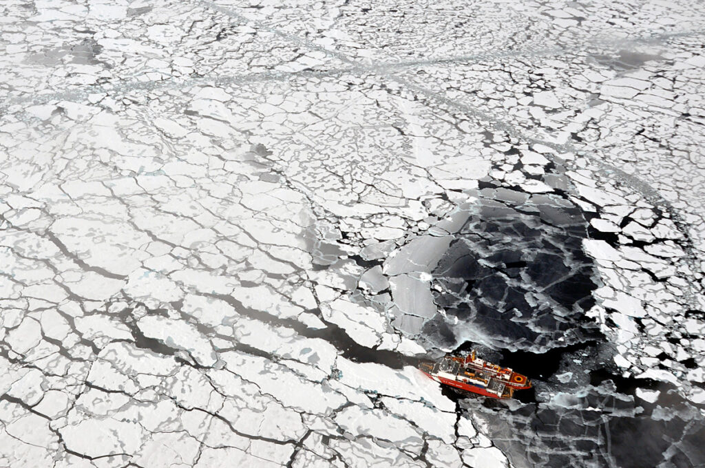 Aerial view of a Canadian Coast Guard ship and a U.S. Coast Guard cutter beside each other amid sea ice