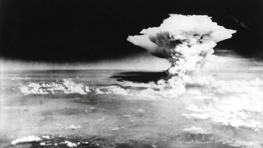 Black and white image taken from the air of a massive plume of smoke and a pyrocumulonimbus cloud over Earth’s surface