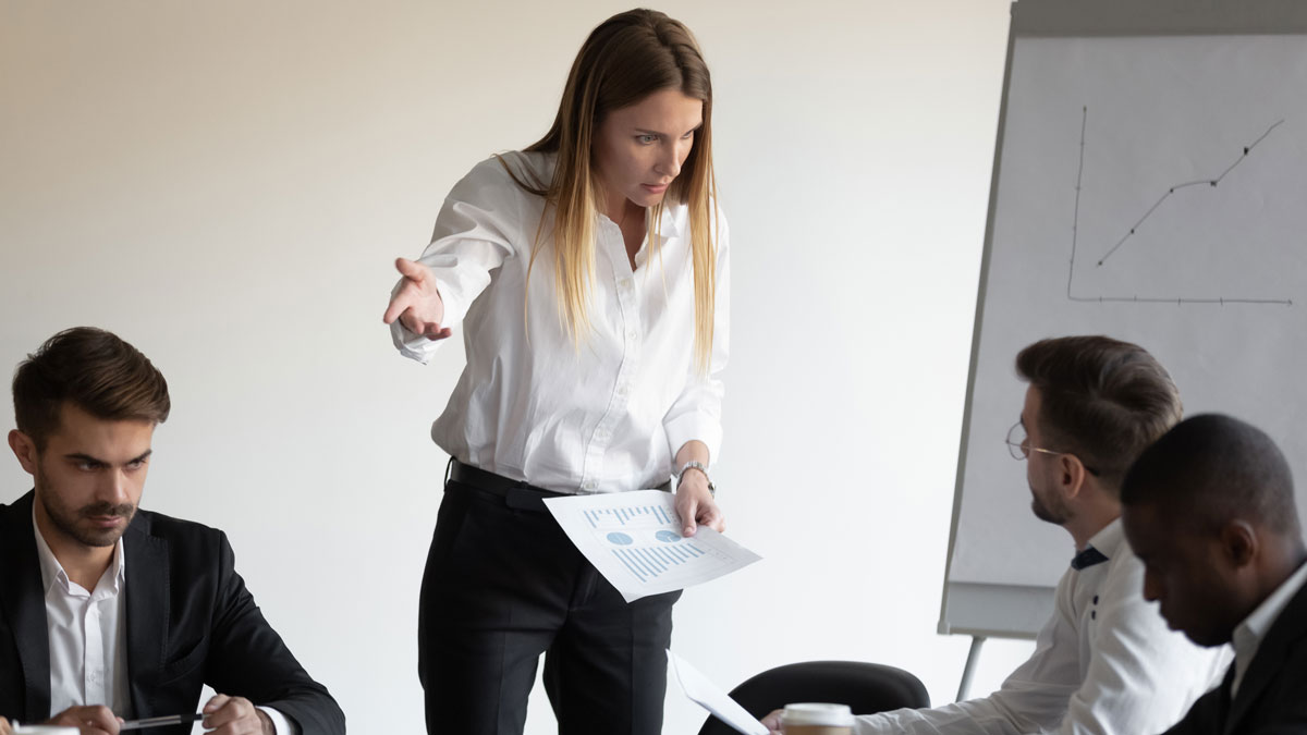 At group meeting businesspeople gathered in boardroom witness a conflict between a boss and an employee.