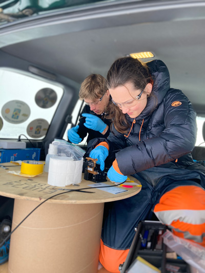 Researchers work in the back of a truck.