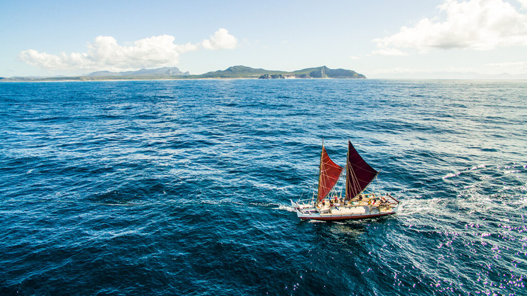 The voyaging canoe Hōkūleʻa sails with Cape Town, South Africa, in the background.